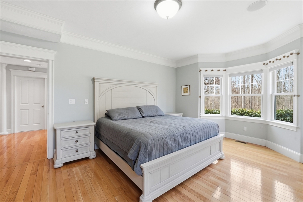 22 McNeil Circle, Unit 22 Hopkinton, MA 01748 - Photo 19 of 42 a bedroom with a large bed and wooden floor