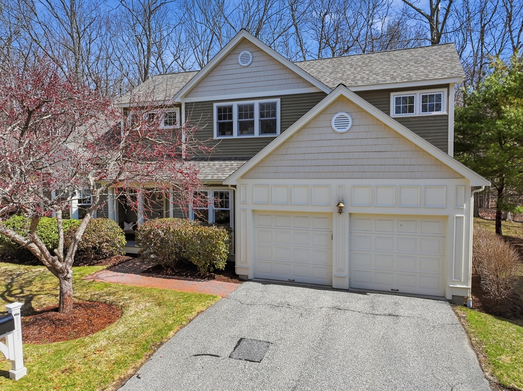 22 McNeil Circle, Unit 22 Hopkinton, MA 01748 - Photo 2 of 42 a front view of a house with a yard and garage