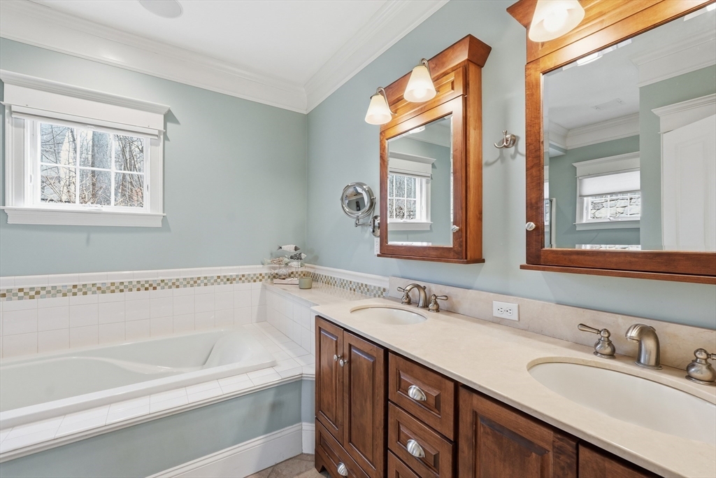22 McNeil Circle, Unit 22 Hopkinton, MA 01748 - Photo 22 of 42 a bathroom with a granite countertop sink mirror and a bathtub