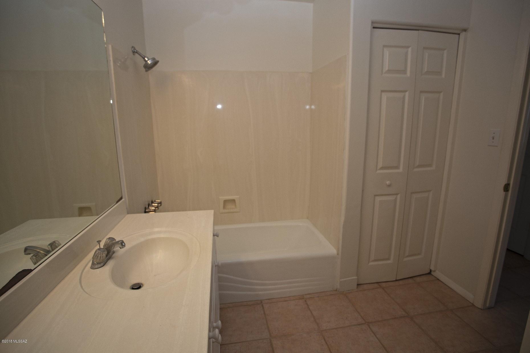 5851 South Avra Road Tucson, AZ 85735 - Photo 20 of 46 a bathroom with a tub sink and vanity