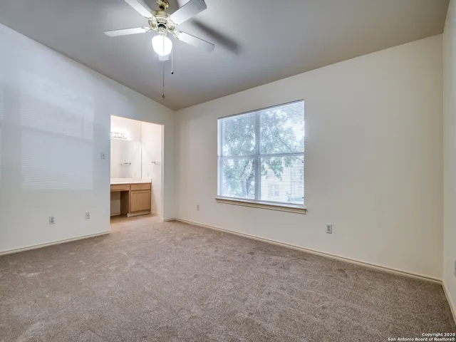 en empty room with windows and ceiling fan