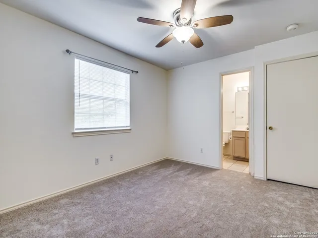 an empty room with a window and a fan