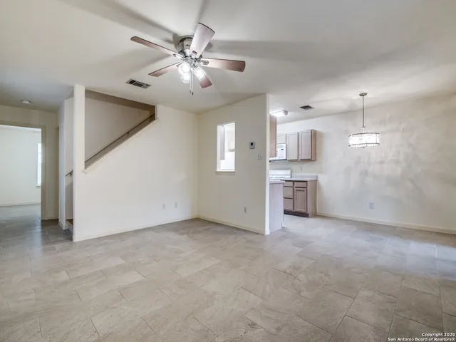 a view of a kitchen with a sink and chandelier fan