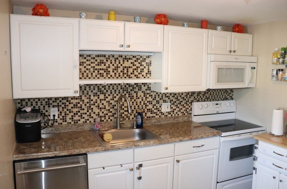 2 Genetti Circle, Unit 2 Bedford, MA 01730 - Photo 4 of 6 a kitchen with granite countertop white cabinets and white appliances
