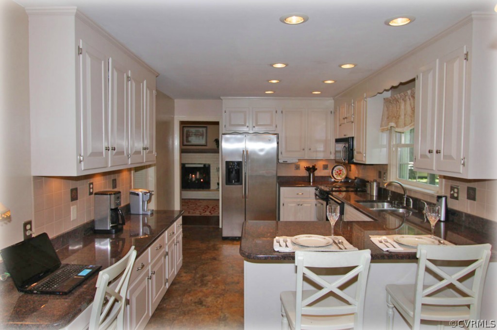 13321 Kingsmill Road Midlothian, VA 23113 - Photo 4 of 14 a kitchen with stainless steel appliances kitchen island granite countertop a refrigerator and cabinets