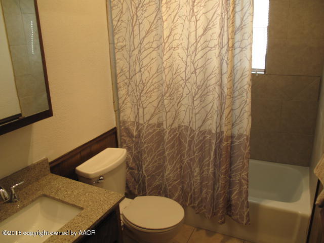 8108 Goodnight Trail Amarillo, TX 79110 - Photo 12 of 17 a white toilet sitting next to a white sink and vanity