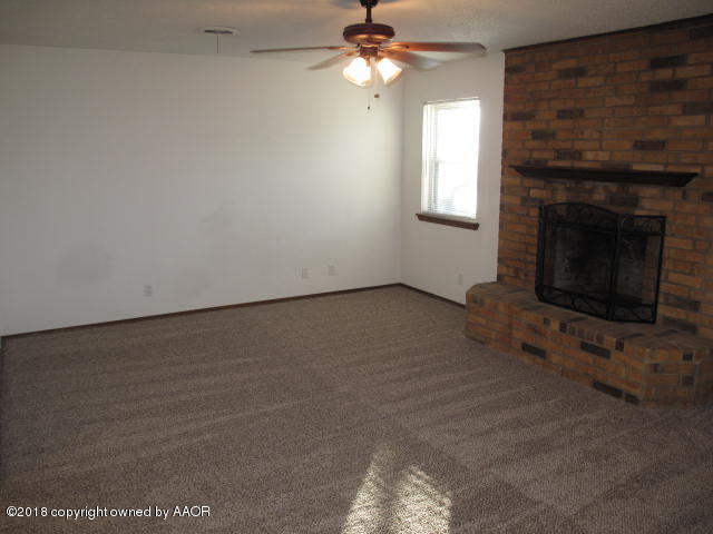8108 Goodnight Trail Amarillo, TX 79110 - Photo 5 of 17 an empty room with a fireplace and fan