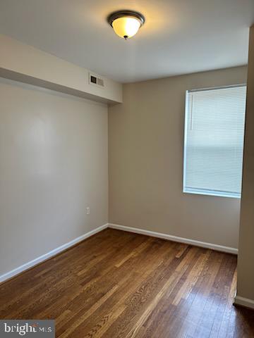 1913 Rosedale Street Northeast, Unit 1 Washington, DC 20002 - Photo 2 of 12 an empty room with wooden floor and windows