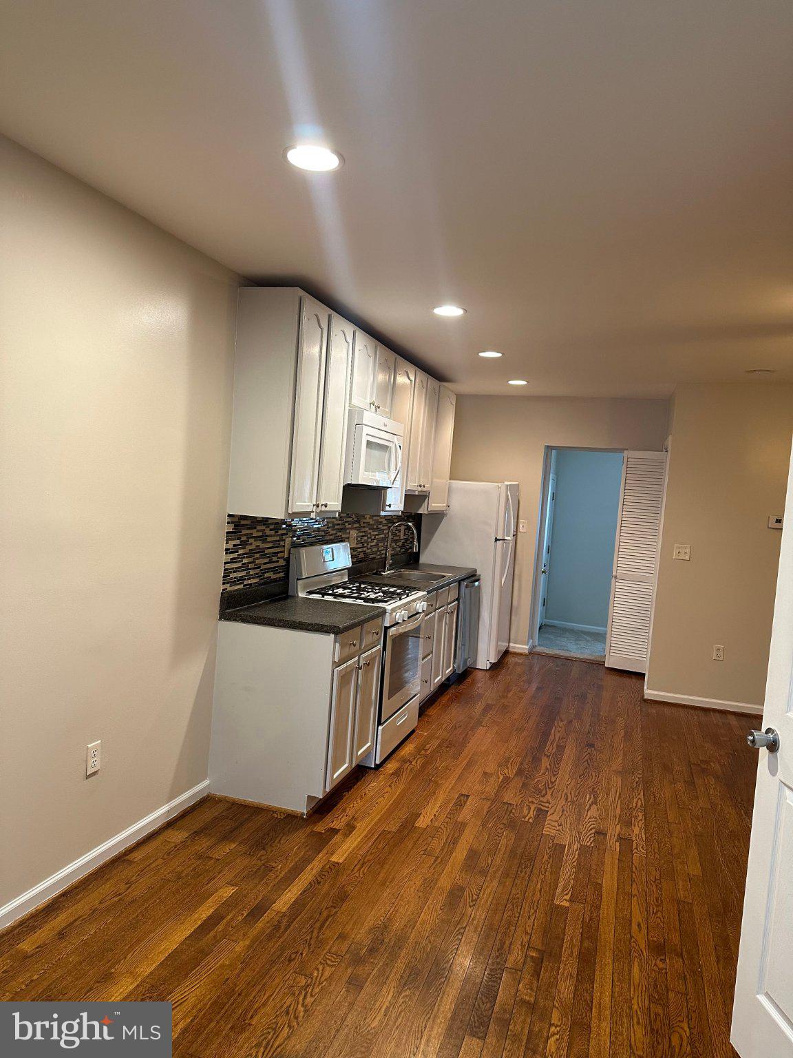 1913 Rosedale Street Northeast, Unit 1 Washington, DC 20002 - Photo 9 of 12 a kitchen with stainless steel appliances granite countertop a stove a sink and a refrigerator