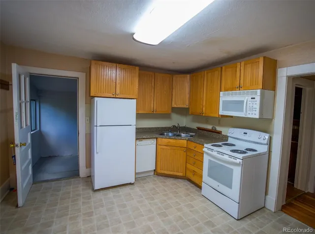 a kitchen with stainless steel appliances granite countertop a refrigerator sink and stove