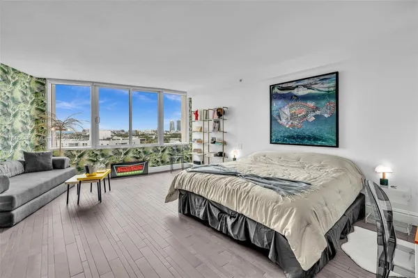 a bedroom with a bed a table and a large mirror