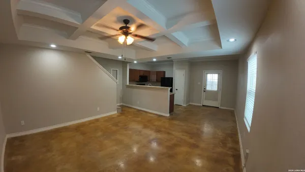 an empty room with windows and ceiling fan