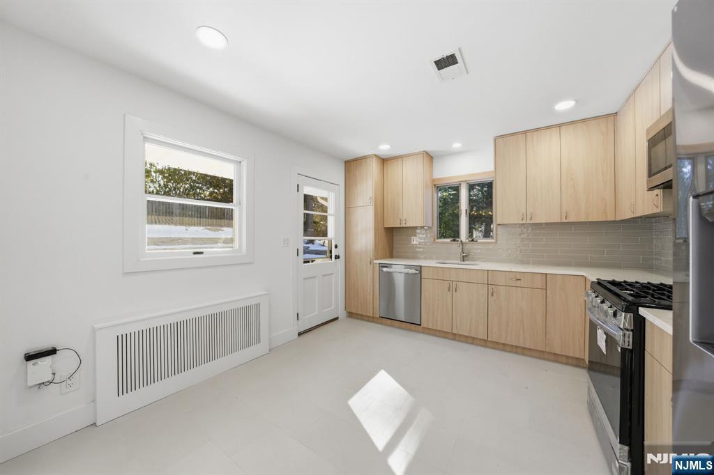 40 Magnolia Avenue Tenafly, NJ 07670 - Photo 12 of 48 a kitchen with white cabinets and white appliances
