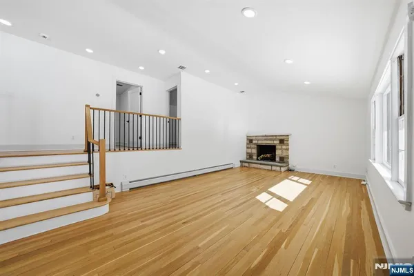 a view of empty room with wooden floor and fireplace