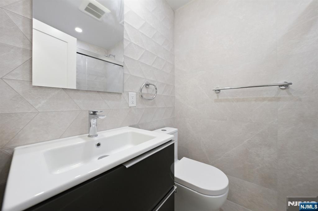40 Magnolia Avenue Tenafly, NJ 07670 - Photo 29 of 48 a bathroom with a toilet a sink a mirror and vanity