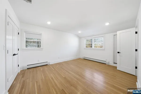 a view of empty room with wooden floor