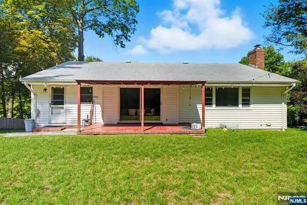 an aerial view of residential house with outdoor space and trees all around