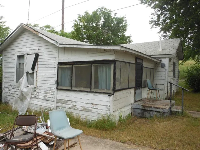 a view of a chair and table in backyard of the house
