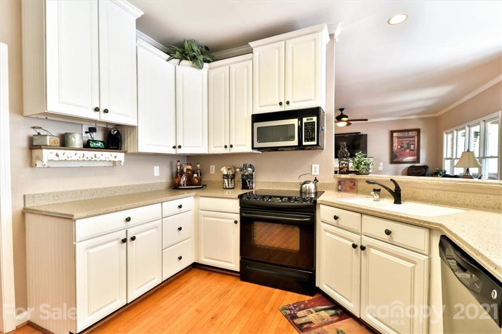 796 Portpatrick Place Fort Mill, SC 29708 - Photo 6 of 48 a kitchen with stainless steel appliances granite countertop a stove top oven a sink dishwasher and white cabinets with wooden floor