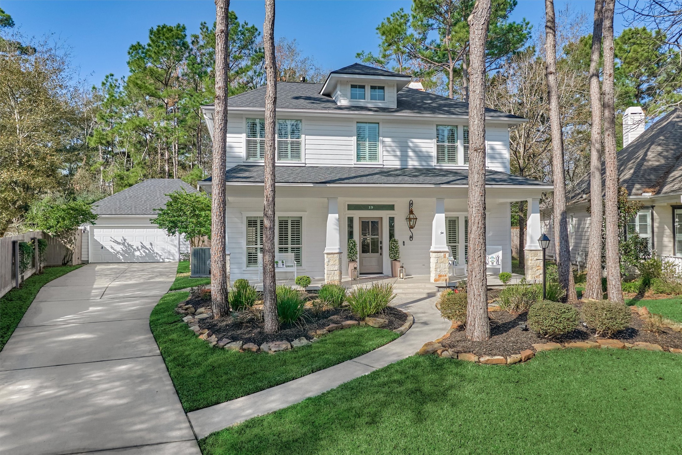 a front view of a house with a yard and potted plants