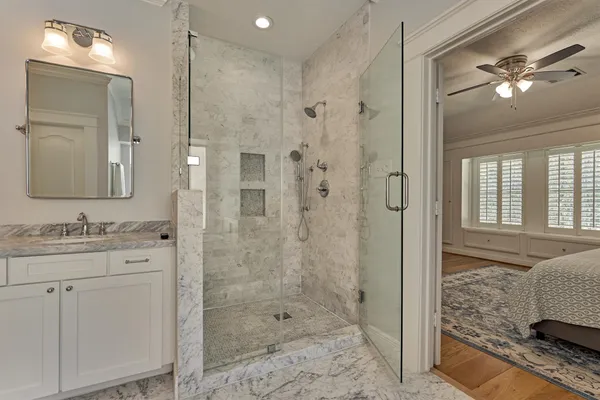 a bathroom with a double vanity sink a toilet a mirror and shower