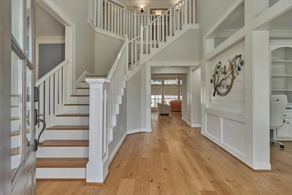 a view of hallway with stairs and wooden floor