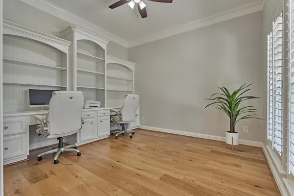 a view of a workspace with furniture and a window