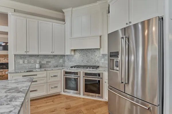 a kitchen with stainless steel appliances granite countertop a refrigerator stove and sink