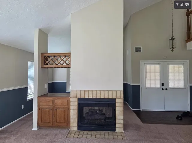 a living room with furniture a flat screen tv and kitchen view