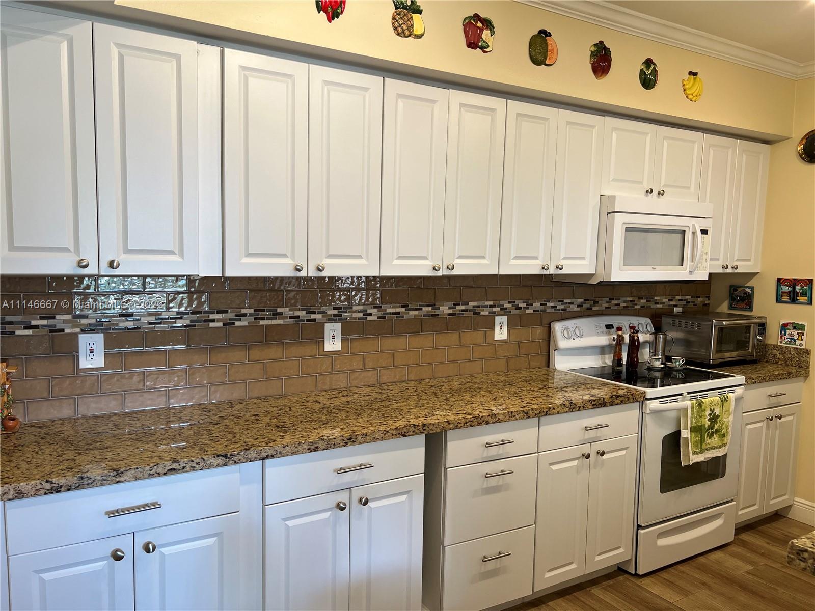 17100 North Bay Road, Unit 1701 Sunny Isles Beach, FL 33160 - Photo 16 of 84 a kitchen with stainless steel appliances granite countertop a stove a sink and white cabinets