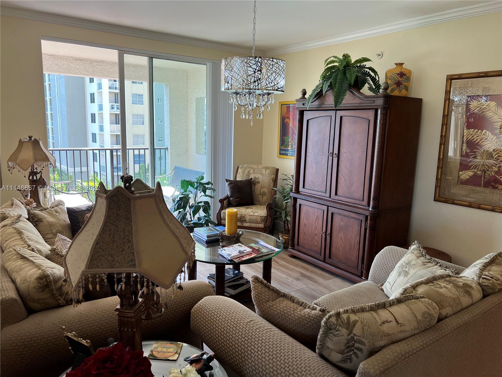 17100 North Bay Road, Unit 1701 Sunny Isles Beach, FL 33160 - Photo 30 of 84 a living room with furniture and a chandelier