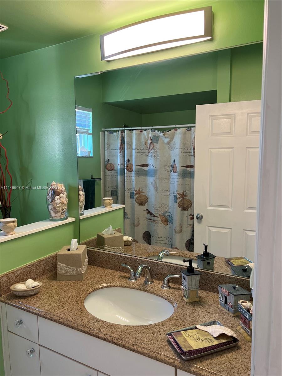 17100 North Bay Road, Unit 1701 Sunny Isles Beach, FL 33160 - Photo 52 of 84 a bathroom with a granite countertop sink and a mirror
