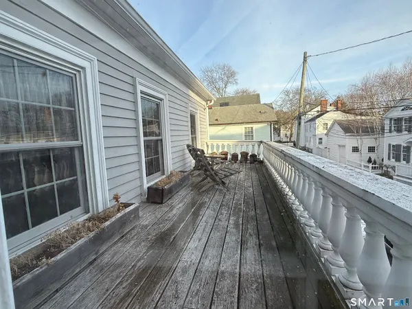a view of a balcony with wooden floor and outdoor seating