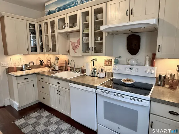 a kitchen with stainless steel appliances a stove and white cabinets