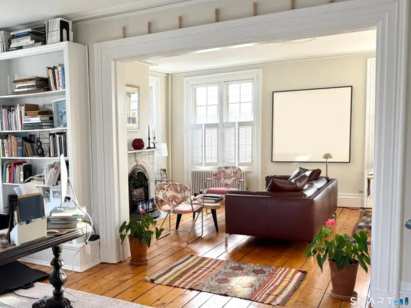 a living room with furniture hard wood floor and a book shelf