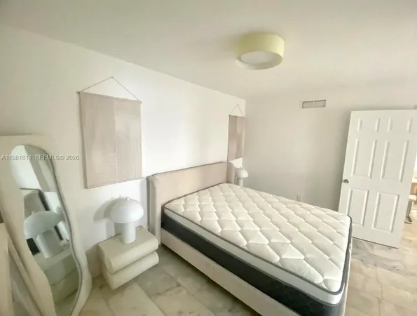 a bed sitting in a bedroom next to a window and walk in closet