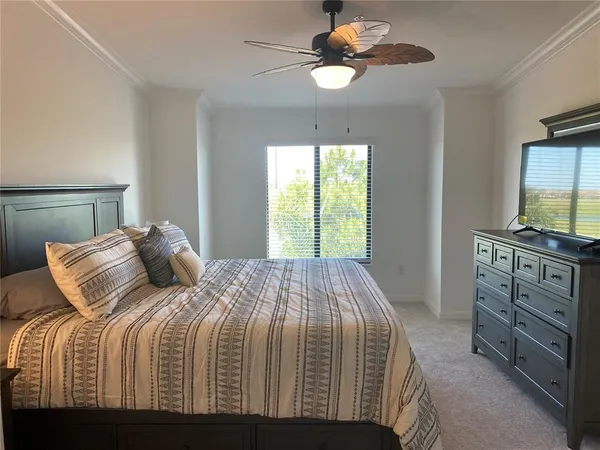 a bedroom with a bed chandelier and a window