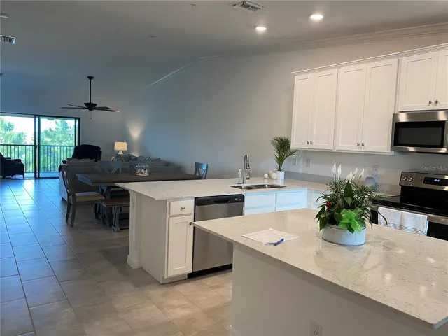 a kitchen with stainless steel appliances a stove a white sink a microwave and cabinets