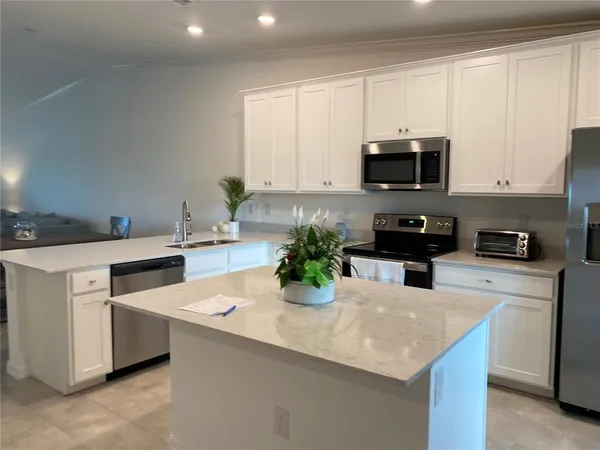 a kitchen with counter top space and living room