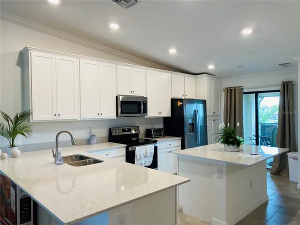 a kitchen with sink a microwave and refrigerator