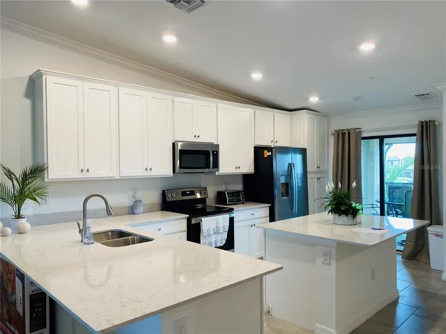 a kitchen with sink a microwave and refrigerator
