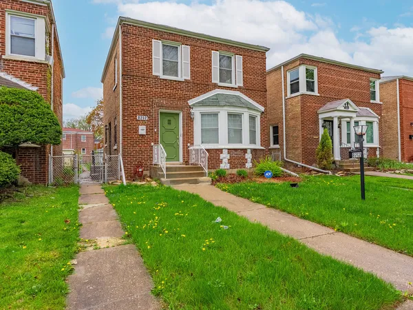 a front view of a house with a yard and garden