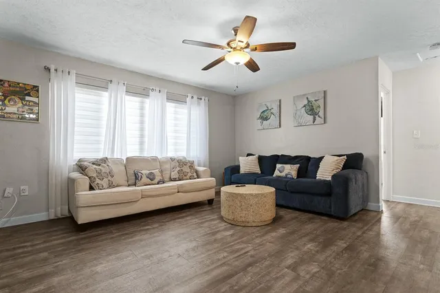 a living room with couches and a view of kitchen