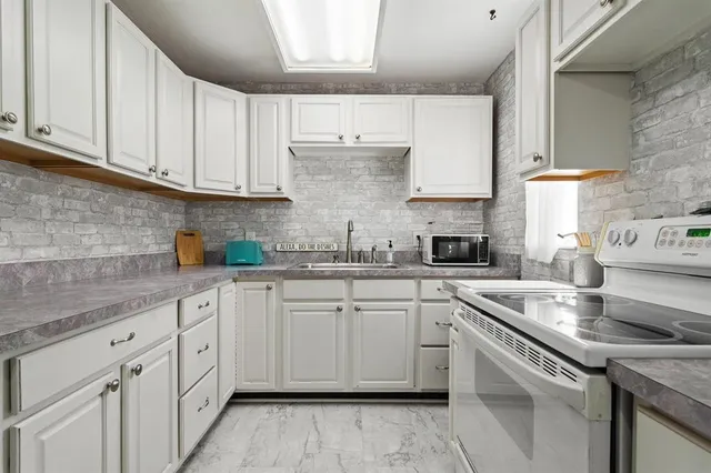 a kitchen with cabinets appliances a sink and a counter top space