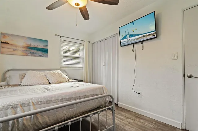a bedroom with a bed and a ceiling fan