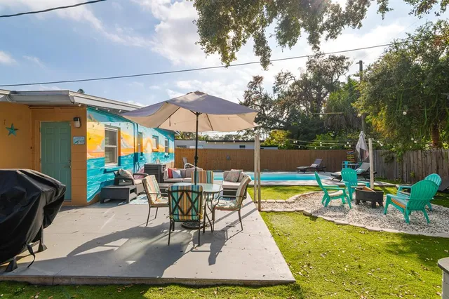 a view of a patio with a table and chairs under an umbrella