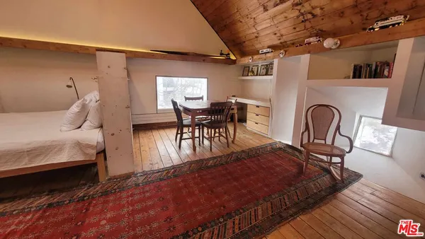 a bed sitting in a room next to a chair