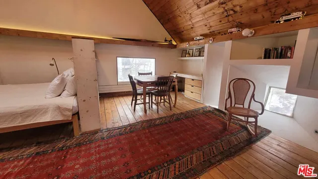 a bed sitting in a room next to a chair