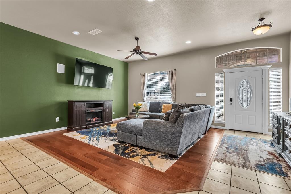 226 King George Road Ponder, TX 76259 - Photo 17 of 39 Living area with light wood finished floors, a warm lit fireplace, recessed lighting, a textured ceiling, and ceiling fan