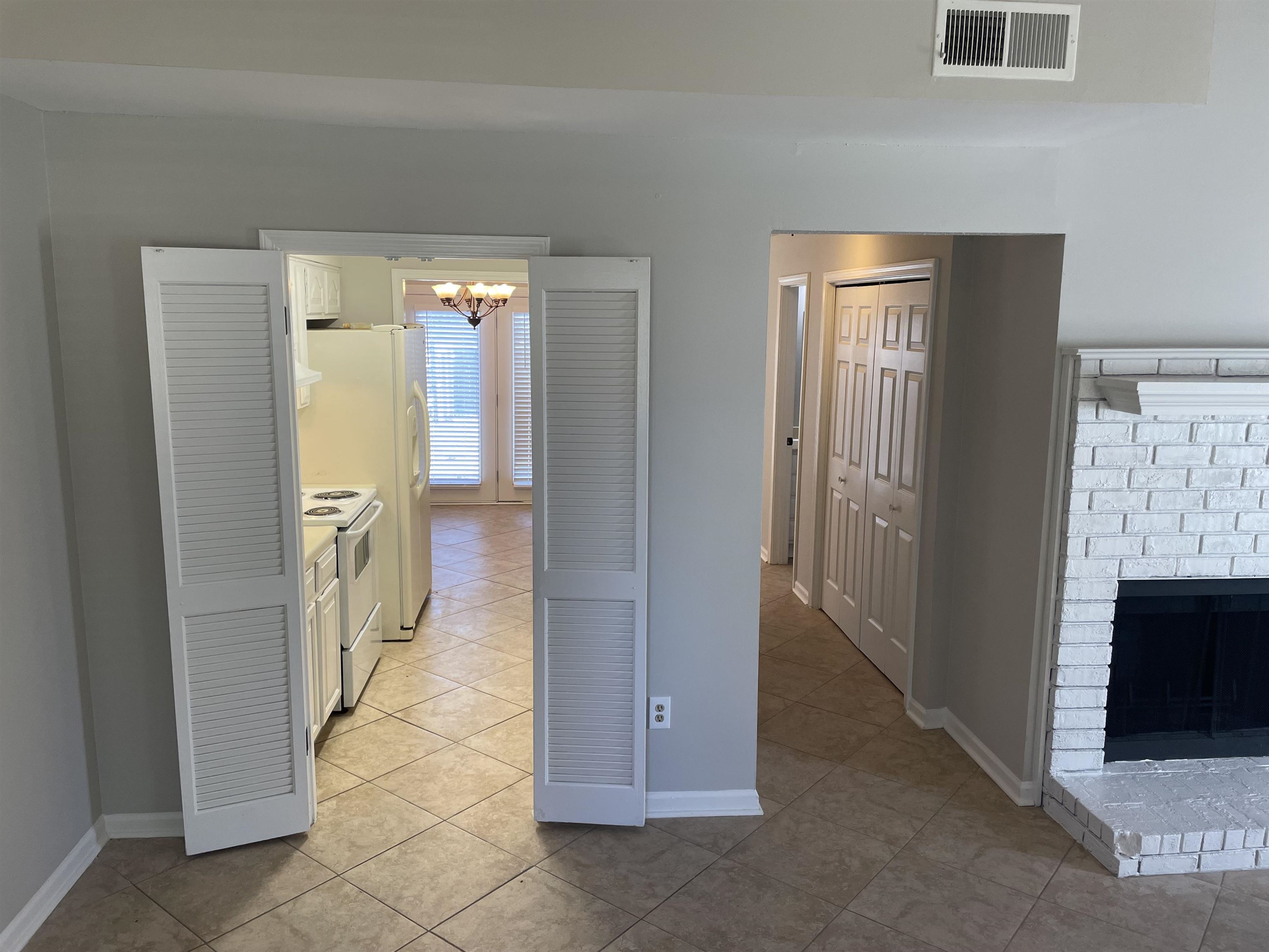 242 South Walnut Bend Road Memphis, TN 38018 - Photo 5 of 17 Kitchen with a notable chandelier, white electric range oven, light tile patterned floors, and a fireplace